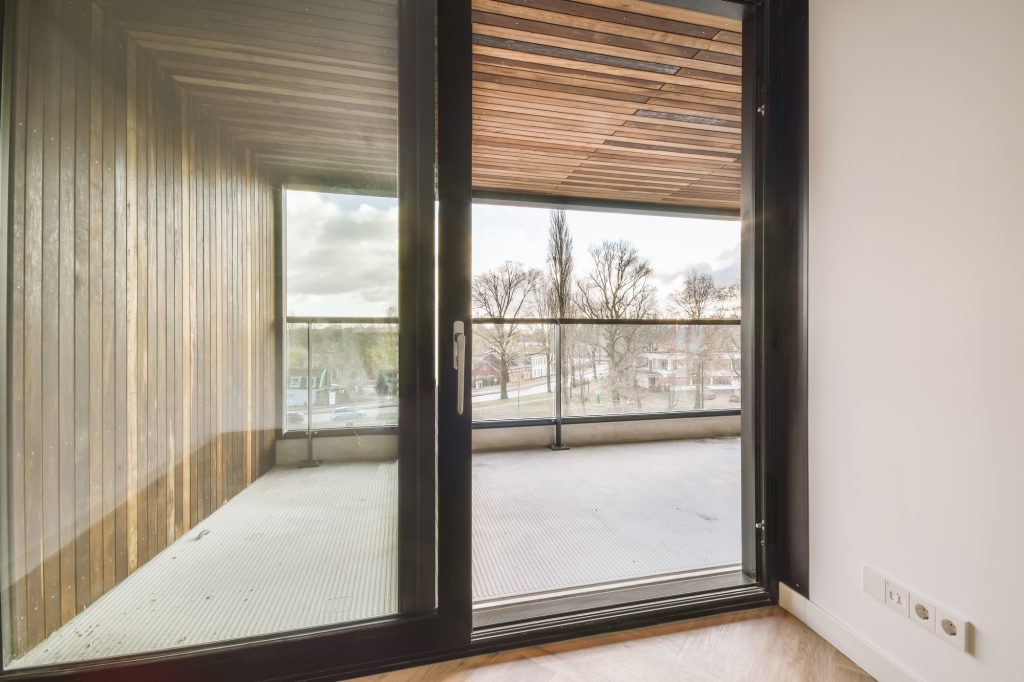 Design of a room with a glass door leading to a balcony