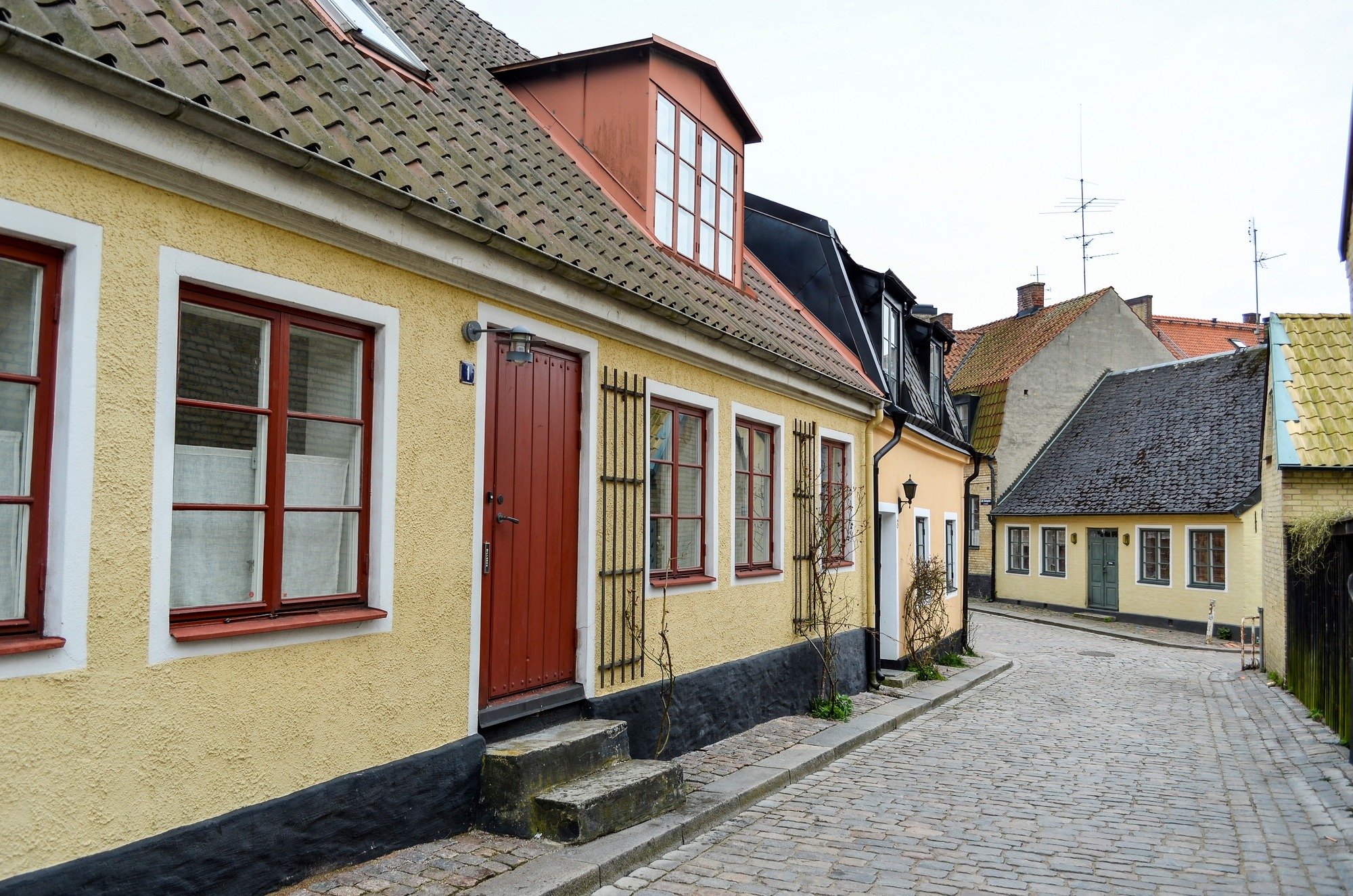 Exterior of single-storey residential building on a cobbled street in Copenhagen, Denmark.